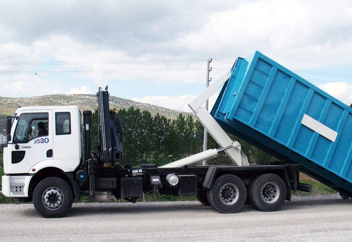 Image of a hook lift bin on a back of a truck for large waste disposal.